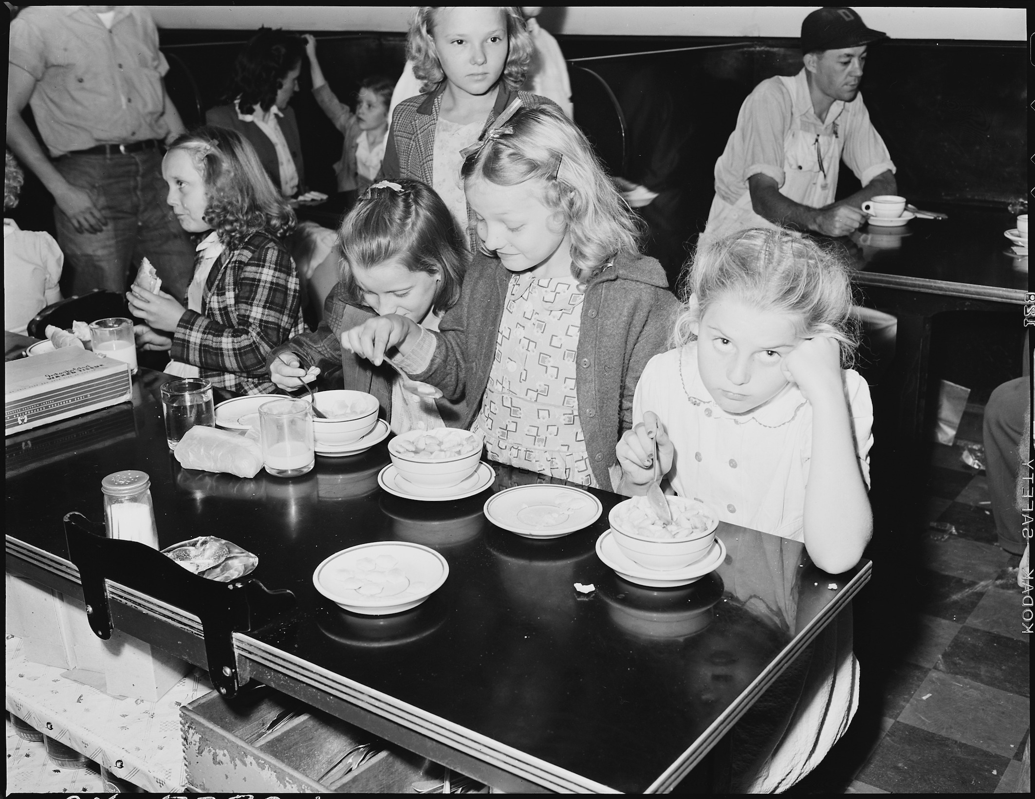 Black and white photo of children eating lunch